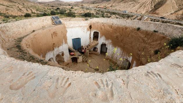 Saliha Mohamedi, 36, sits with her children at their house. These houses are concentrated around Matmata, in a cratered landscape dotted with palm trees and olive groves. Similar constructions are also found across the border in Libya, to the southwest. In other parts of Djebel Dahar, houses and storerooms were carved from rock and earth, but above ground. (Zohra Bensemra / REUTERS) Saliha Mohamedi, 36, sits with her children at their house. These houses are concentrated around Matmata, in a cratered landscape dotted with palm trees and olive groves. Similar constructions are also found across the border in Libya, to the southwest. In other parts of Djebel Dahar, houses and storerooms were carved from rock and earth, but above ground. (Zohra Bensemra / REUTERS)