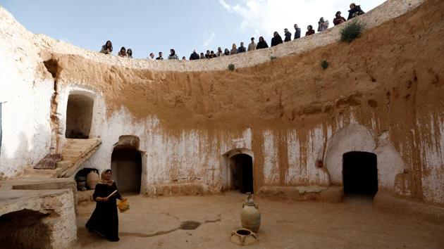 Tunisian tourists watch as Saliha Mohamedi walks around her house. “I don’t want to leave my house, it would be as if I was throwing my life and my traditions away,” she said. Residents live largely off olive farming and tourism. Matmata became a popular destination after a troglodyte home converted into a hotel was used as a Star Wars set in the 1970s. (Zohra Bensemra / REUTERS) Tunisian tourists watch as Saliha Mohamedi walks around her house. “I don’t want to leave my house, it would be as if I was throwing my life and my traditions away,” she said. Residents live largely off olive farming and tourism. Matmata became a popular destination after a troglodyte home converted into a hotel was used as a Star Wars set in the 1970s. (Zohra Bensemra / REUTERS)