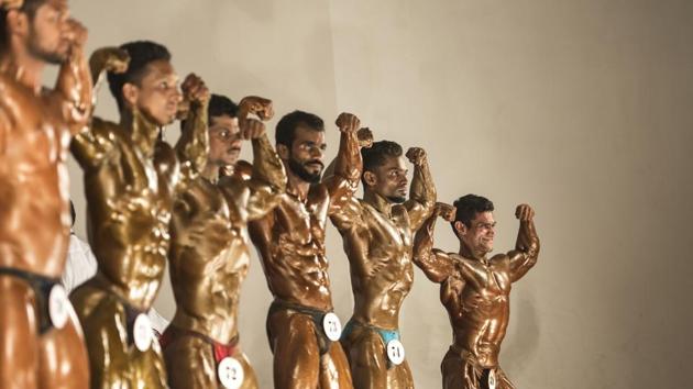 Musclemen take a part in the 14th Maharashtra Shree Bodybuilding Competition held in Bandra (East), Mumbai. (Satish Bate/HT)