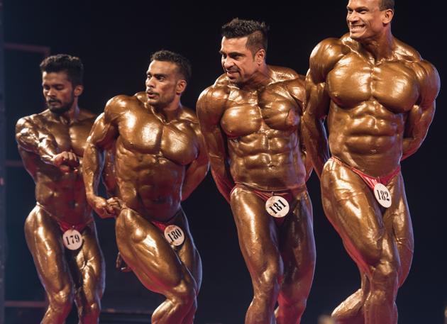 Participants flex their muscles for the judges. (Satish Bate/HT)