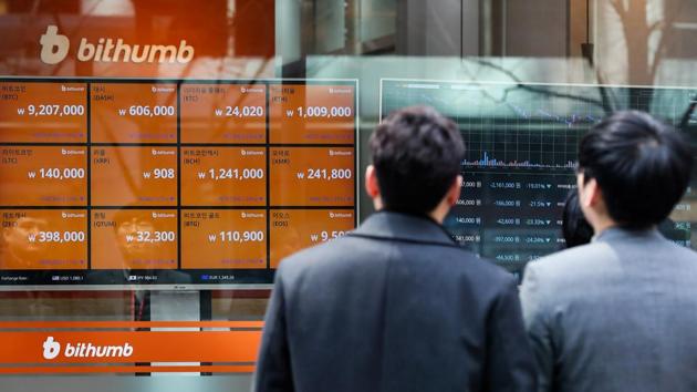 Pedestrians look at monitors showing the prices of virtual currencies at the Bithumb exchange office in Seoul.(Bloomberg via Getty Images) Pedestrians look at monitors showing the prices of virtual currencies at the Bithumb exchange office in Seoul.(Bloomberg via Getty Images)