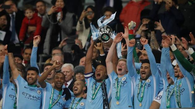 Manchester City’s Vincent Kompany lifts the League Cup trophy as they celebrate after beating Arsenal at the Wembley Stadium in London on Sunday.(Reuters) Manchester City’s Vincent Kompany lifts the League Cup trophy as they celebrate after beating Arsenal at the Wembley Stadium in London on Sunday.(Reuters)