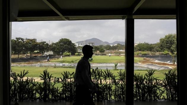An employee walks though a golf club in Palava City on the outskirts of Mumbai.(Dhiraj Singh/Bloomberg) An employee walks though a golf club in Palava City on the outskirts of Mumbai.(Dhiraj Singh/Bloomberg)