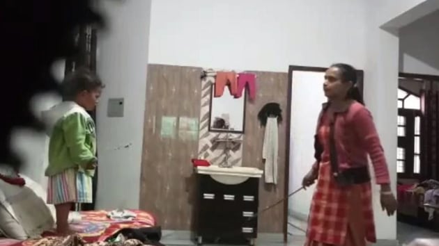 A video grab showing the maid with a wooden stick. A video grab showing the maid with a wooden stick.