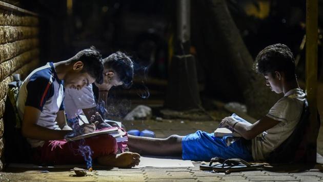 Boys read in the night with lit incense sticks to keep mosquitoes away in Worli. Libraries are shut at night and many find refuge in corners on the city’s streets to catch up on reading that they might’ve had no time for in the day. Some even study on the streets at night. (Kunal Patil / HT Photo) Boys read in the night with lit incense sticks to keep mosquitoes away in Worli. Libraries are shut at night and many find refuge in corners on the city’s streets to catch up on reading that they might’ve had no time for in the day. Some even study on the streets at night. (Kunal Patil / HT Photo)