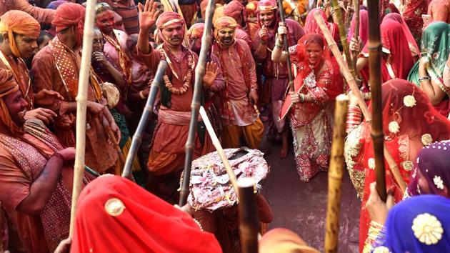A man from Barsana fends off women at the Nand Ji Temple in Nandgaon. Lathmar Holi is celebrated 4 days before Holi proper and is a jumpstart to celebrations of the festival of colours marking the end of winter, thanksgiving for a good harvest and the victory of good over evil. (Ajay Aggarwal / HT Photo) 