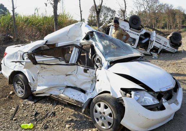A policeman inspects a car that crashed into an SUV on Solapur-Tuljapur Road in Solapur on Tuesday. At least five people were killed and seven others injured during the mishap. (PTI)