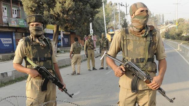 Policemen stand guard near the site of a gunfight between militants and forces near Srinagar airport in October 2017.(HT file) Policemen stand guard near the site of a gunfight between militants and forces near Srinagar airport in October 2017.(HT file)