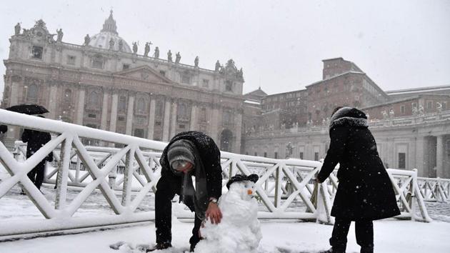 People build a snowman as it snows at St Peter's square on February 26, 2018 at the Vatican.(AFP) People build a snowman as it snows at St Peter's square on February 26, 2018 at the Vatican.(AFP)