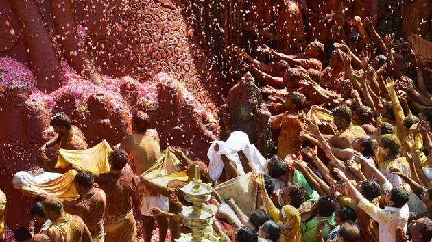Devotees offer flower petals on the 58 feet monolithic statue of Gomateshwara or Lord Bahubali on the second day. (PTI) Devotees offer flower petals on the 58 feet monolithic statue of Gomateshwara or Lord Bahubali on the second day. (PTI)