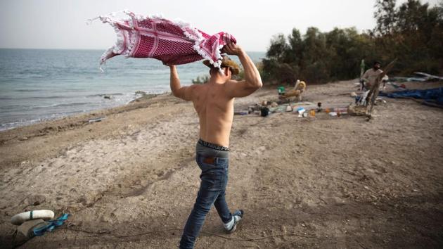 Levi holds a keffiyeh, an Arab head scarf, as he walks along the shore of the Dead Sea. A rocky trail leads down the desert road to Metzoke Dragot. The beach is in the northern part of the Dead Sea that borders Israel, the West Bank and Jordan. Over centuries the ancient lake has drawn monks, early Christians, Jewish sects, travelers seeking spiritual elation and tourists who enjoy floating and mud-baths. (Ronen Zvulun / REUTERS) Levi holds a keffiyeh, an Arab head scarf, as he walks along the shore of the Dead Sea. A rocky trail leads down the desert road to Metzoke Dragot. The beach is in the northern part of the Dead Sea that borders Israel, the West Bank and Jordan. Over centuries the ancient lake has drawn monks, early Christians, Jewish sects, travelers seeking spiritual elation and tourists who enjoy floating and mud-baths. (Ronen Zvulun / REUTERS)
