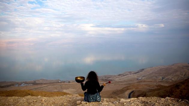 A naked man covered in mud lies on a beach, while nearby a dreadlocked recluse reads from the Book of Exodus and a woman strikes a low soothing note from a Tibetan singing bowl. It’s sunset at the Metzoke Dragot beach by the Dead Sea, one of the last unspoiled spots at the lowest point on the planet where the New Age melds with a biblical vista in danger of becoming a paradise lost. (Ronen Zvulun / REUTERS) A naked man covered in mud lies on a beach, while nearby a dreadlocked recluse reads from the Book of Exodus and a woman strikes a low soothing note from a Tibetan singing bowl. It’s sunset at the Metzoke Dragot beach by the Dead Sea, one of the last unspoiled spots at the lowest point on the planet where the New Age melds with a biblical vista in danger of becoming a paradise lost. (Ronen Zvulun / REUTERS)