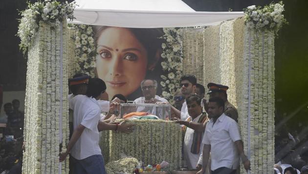 The late actor’s husband Boney Kapoor (C), nephew Mohit Marwah and Arjun Kapoor were seen on the hearse as the procession made its way to the cremation ground with her body draped in the tricolour, followed by a large procession of mourners. (Rafiq Maqbool / AP) 