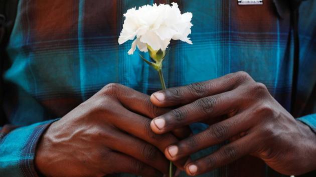 A fan  holds a flower as he waits to offer his condolences outside a makeshift memorial in Mumbai. Long queues of fans holding flowers in their hands and chanting prayers were seen as the body of the actor was brought to the venue along with an entourage of family members. (Danish Siddiqui / REUTERS) 