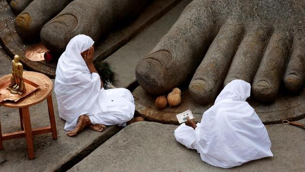 Women devotees sit at the feet of the monolithic statue of Jain deity Gomateshwara as they celebrate the anointing ceremony of the statue. While lakhs of people are thronging to the shrine to participate in what is also called as ‘Jain Maha Kumbh’, only several selected devotees made their way up the 618 steps leading to the statue. (REUTERS) Women devotees sit at the feet of the monolithic statue of Jain deity Gomateshwara as they celebrate the anointing ceremony of the statue. While lakhs of people are thronging to the shrine to participate in what is also called as ‘Jain Maha Kumbh’, only several selected devotees made their way up the 618 steps leading to the statue. (REUTERS)