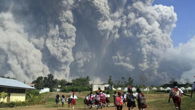 In this Feb. 19 2018, file photo, school children walk as Mount Sinabung erupts in Karo, North Sumatra, Indonesia. Rumbling Mount Sinabung on the Indonesian island of Sumatra has shot billowing columns of ash more than 5,000 meters (16,400 feet) into the atmosphere and hot clouds down its slopes (AP) In this Feb. 19 2018, file photo, school children walk as Mount Sinabung erupts in Karo, North Sumatra, Indonesia. Rumbling Mount Sinabung on the Indonesian island of Sumatra has shot billowing columns of ash more than 5,000 meters (16,400 feet) into the atmosphere and hot clouds down its slopes (AP)