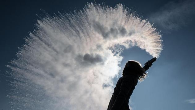 A woman tosses hot water into the freezing cold air that is immediately turned into a sparkling cloud of snow in Berlin. (AFP Photo) A woman tosses hot water into the freezing cold air that is immediately turned into a sparkling cloud of snow in Berlin. (AFP Photo)
