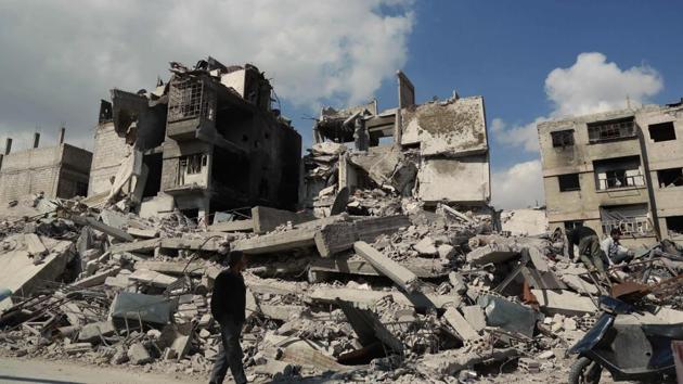 A Syrian man walks past a buildings which was destroyed earlier in regime air strikes, in the rebel-held besieged town of Douma in the eastern Ghouta region, on the outskirts of the capital Damascus, on February 28, 2018. (AFP Photo) A Syrian man walks past a buildings which was destroyed earlier in regime air strikes, in the rebel-held besieged town of Douma in the eastern Ghouta region, on the outskirts of the capital Damascus, on February 28, 2018. (AFP Photo)