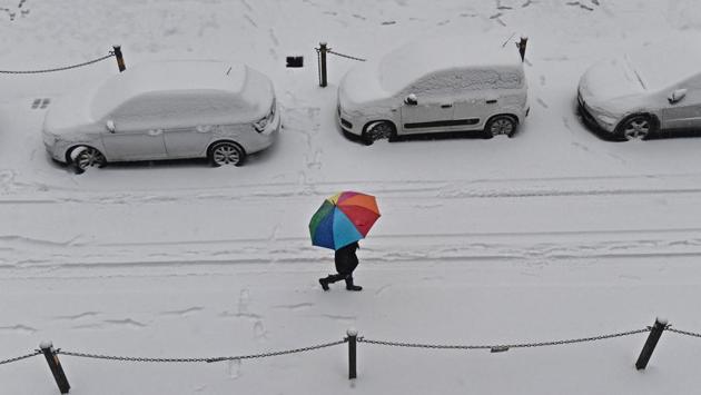 A woman shelters herself under a coloured umbrella as she walks in Florence, Italy. Meteorologists say that the cold spell could last for up to two weeks, and that even with temperatures expected to rise during the day next week, temperatures will most likely remain close to freezing at night. (Maurizio degl'Innocenti / AP)
