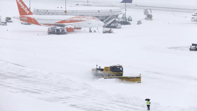 A plough removes snow next to EasyJet and Lufhansa aircraft during a temporary closure at Cointrin airport in Geneva, Switzerland. Nearly all train operators warned of cancellations and disruption and hundreds of flights were cancelled. (Pierre Albouy / REUTERS)