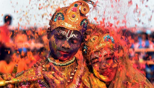 Tribal students from the Kalinga Institute of Social Science (KISS), dressed as Lord Krishna and Radha, are smeared with coloured powder and petals during Holi celebrations in Bhubaneswar. (Asit Kumar / AFP) Tribal students from the Kalinga Institute of Social Science (KISS), dressed as Lord Krishna and Radha, are smeared with coloured powder and petals during Holi celebrations in Bhubaneswar. (Asit Kumar / AFP)