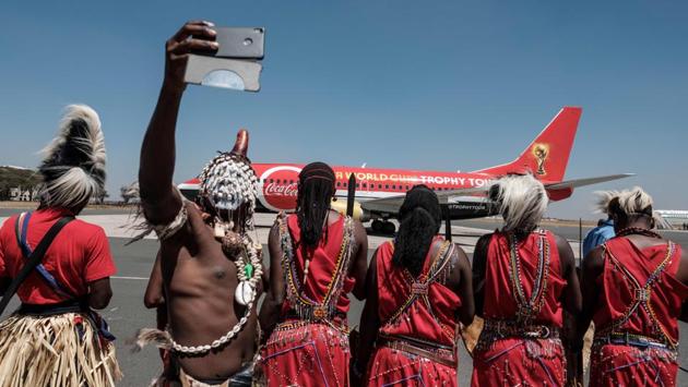 A dancer takes a picture upon the arrival of the special aircraft carrying the FIFA World Cup Trophy during its World Tour at the Jomo Kenyatta International airport in Nairobi. (Yasuyoshi Chiba / AFP) 
