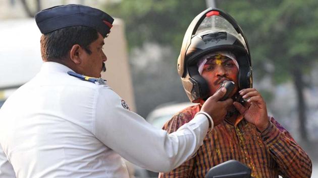 As a precautionary measure, a traffic police checks a man for drunk and drive during the Holi celebrations on Friday. (pratham gokhale/ht photo) As a precautionary measure, a traffic police checks a man for drunk and drive during the Holi celebrations on Friday. (pratham gokhale/ht photo)