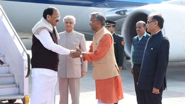 Chief minister TS Rawat greets Vice President Venkiah Naidu at the airport along with governor KK Paul.(HT Photo)