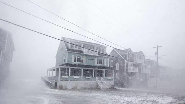 Waves crash over a house on Lighthouse Rd. as the road starts to flood during a large coastal storm on March 2, 2018 in Scituate, Massachusetts. (AFP)