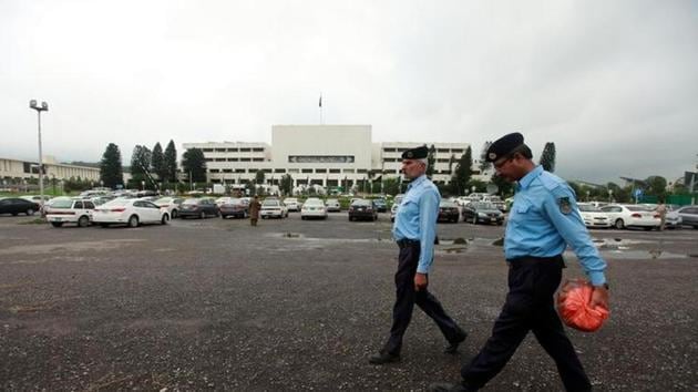 Policemen walk past in front of the Pakistan Parliament House. (Reuters file) Policemen walk past in front of the Pakistan Parliament House. (Reuters file)