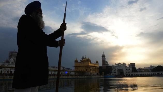 An Sikh Sewadar volunteer stands near the Sikh Golden Temple as dark clouds are seen over it, in Amritsar. (Narnder Nanu / AFP) An Sikh Sewadar volunteer stands near the Sikh Golden Temple as dark clouds are seen over it, in Amritsar. (Narnder Nanu / AFP)