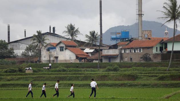 Students walk through rice fields located in Majalaya, a town densely populated with textile factories. Among the river’s worst polluters are dozens of textile factories in Majalaya that dump chemical waste, Arif Havas Oegroseno, a deputy minister who coordinates maritime affairs told Reuters. (Darren Whiteside / REUTERS)