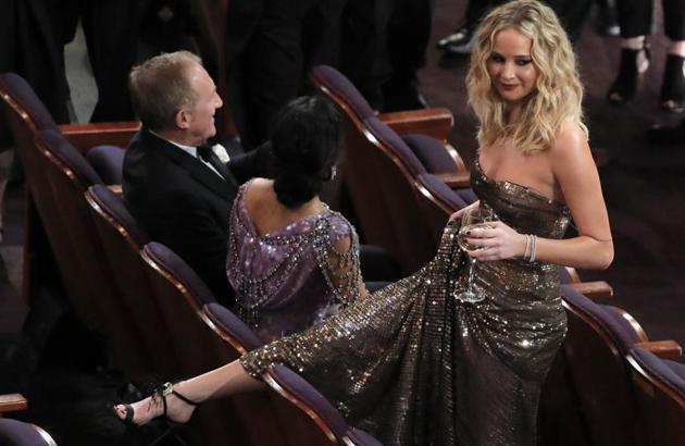 Salma Hayek and her husband Francois-Henri Pinault sit as Jennifer Lawrence attempts to skip over seats.(REUTERS)