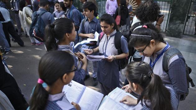 Students of Class X and XII are seen caught up in last minute revisions, outside an examination centre, at Kendra Vidyalaya Gole Market in New Delhi. For the Class 12 exam, 11,86,306 candidates had registered and exams began today at 4,138 centres in India and 71 centres abroad. (Burhaan Kinu / HT Photo) 