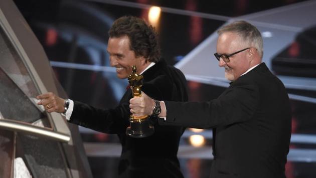 Matthew McConaughey (L) gestures to the audience as winner Lee Smith holds up the award for best film editing for "Dunkirk" at the Dolby Theatre in Los Angeles. (Chris Pizzello / Chris Pizzello / Invision / AP)