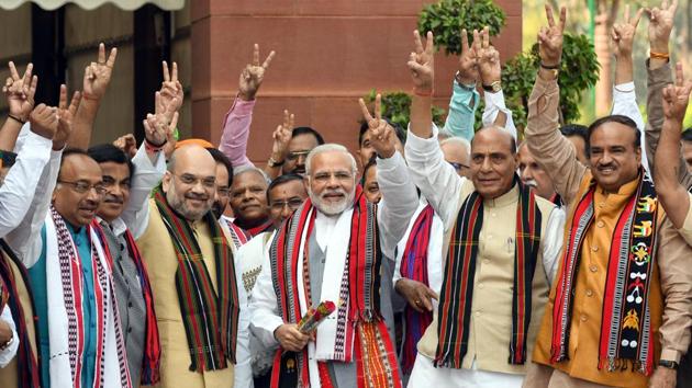 Prime minister Narendra Modi, BJP National President Amit Shah, Union Home Minister Rajnath Singh along with other cabinet ministers pose with victory signs after their win in North East State elections, during the parliament budget session in New Delhi on Monday. (Sonu Mehta / HT Photo) 