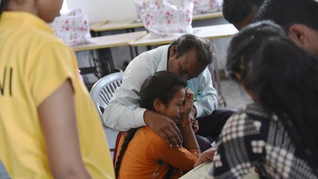 Shobha (centre) is seen in an emotional moment with her father, who came to visit her after a long break. Currently in 12th grade, with exams around the corner, Shobha was upset over a small incident the day before and seeing her father probably triggered an array of emotions. Parents are allowed to visit their children on the last two Sundays of each month. (Anushree Fadnavis / HT Photo) 