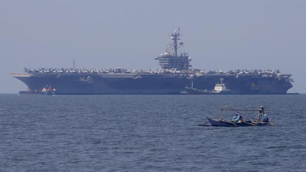 Fishermen on board a small boat pass by the USS Carl Vinson aircraft carrier at anchor off Manila, Philippines on February 17. (AP File Photo) Fishermen on board a small boat pass by the USS Carl Vinson aircraft carrier at anchor off Manila, Philippines on February 17. (AP File Photo)