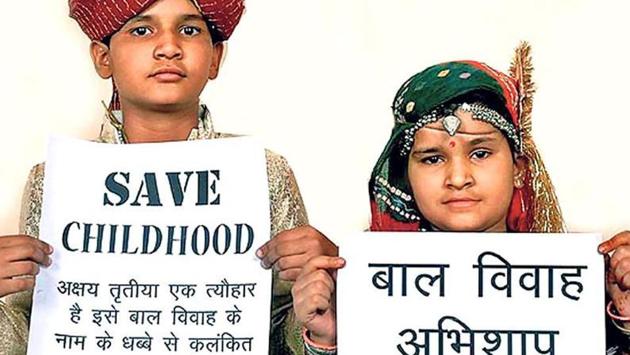 Children hold placards with anti-child marriage slogans. Worldwide, an estimated 650 million women alive today were married as children.(HT File Photo)