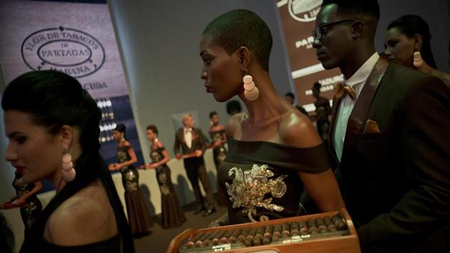 Models carry trays of aged cigars for guests, at a gala dinner of the 20th Cigar Festival in Havana, Cuba. The cigars that leave La Corona include the famed San Cristobal, Montecristo and Romeo and Juliet Churchill lines, which can sell for upward of $700 a box in stores and clubs around the world. (Ramon Espinosa / AP) Models carry trays of aged cigars for guests, at a gala dinner of the 20th Cigar Festival in Havana, Cuba. The cigars that leave La Corona include the famed San Cristobal, Montecristo and Romeo and Juliet Churchill lines, which can sell for upward of $700 a box in stores and clubs around the world. (Ramon Espinosa / AP)