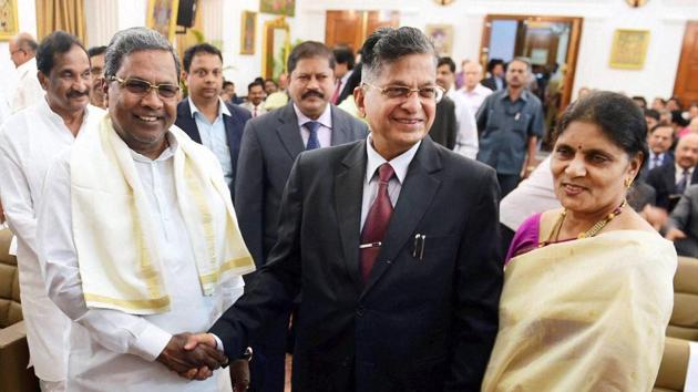 Karnataka chief minister Siddaramaiah greets lokayukta Justice P Vishwanath Shetty and his wife during the swearing in ceremony at Raj Bhavan in Bengaluru.(PTI File Photo)