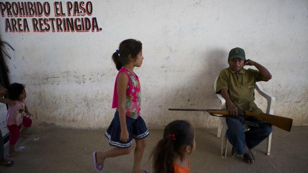 Children walk past an officer at a vigilante force’s base in Ayutla de los Libres. While Mexico’s current situation can be compared with that of Columbia’s in 1980’s and 90’s , with similarities in locals taking it upon themselves to seek justice, the formation of these groups has only deepened the crisis in Mexico causing disruption in law and order and feeding a cycle of violence. (Rebecca Blackwell / AP)