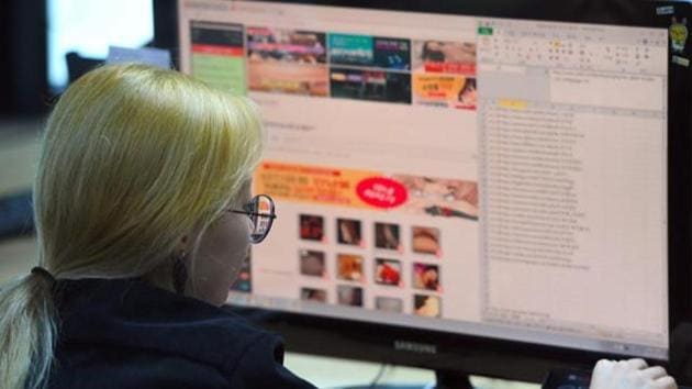 File photo of an employee of a Santa Cruise ‘digital laundry’ company monitoring a computer screen to find ‘revenge porn’ at the company in Seoul. The company is tasked with taking down videos posted without consent — including so-called “revenge porn”.(AFP)