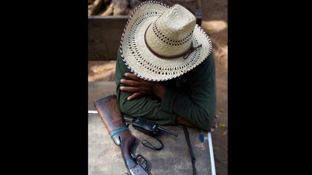 A vigilante sits guard with his rifle and radio outside a base in Mexico. Effectively vigilante outfits with no allegiance, and often outright hostility to elected authorities, these are grassroots attempts by locals to rein in lawlessness in some of the areas most wracked by killings, kidnappings, extortion and other malfeasance. (Rebecca Blackwell / AP)