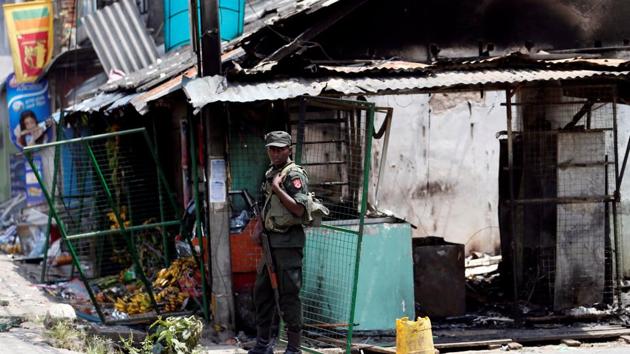 Sri Lanka's army soldier stands guard next to a damaged shop after a clash between two communities in Digana central district of Kandy, Sri Lanka.(Reuters Photo)