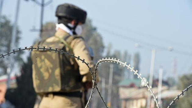 Policeman stands guard near the site of gunfight between suspected militants and government forces in Srinagar.(AFP Photo)