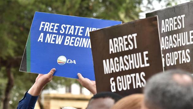 Political activists of the South Africa opposition party Democratic Alliance and of the Economic Freedom Fighters demonstrate in front of the Bloemfontein Regional Court, as the suspects linked to the Estina dairy farm fraud and corruption investigation appeared in court on February 15, 2018. (AFP) Political activists of the South Africa opposition party Democratic Alliance and of the Economic Freedom Fighters demonstrate in front of the Bloemfontein Regional Court, as the suspects linked to the Estina dairy farm fraud and corruption investigation appeared in court on February 15, 2018. (AFP)