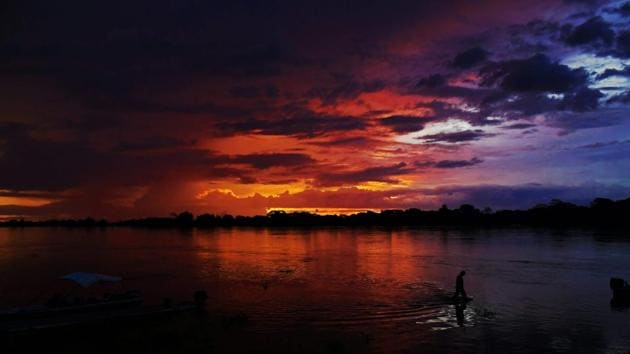 A man wades through a lake at sunset in Pantanal, Mato Grosso, Brazil. (Carl De Souza / AFP) A man wades through a lake at sunset in Pantanal, Mato Grosso, Brazil. (Carl De Souza / AFP)