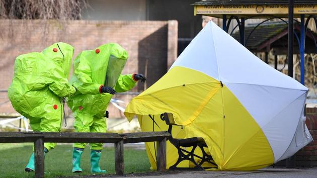 Members of the emergency services in biohazard suits afix a tent over the bench where Russian former double-agent Sergei Skripal, 66 and his daughter Yulia were found on March 4 in critical condition at The Maltings shopping centre in Salisbury, England. (Ben Stansall / AFP) Members of the emergency services in biohazard suits afix a tent over the bench where Russian former double-agent Sergei Skripal, 66 and his daughter Yulia were found on March 4 in critical condition at The Maltings shopping centre in Salisbury, England. (Ben Stansall / AFP)