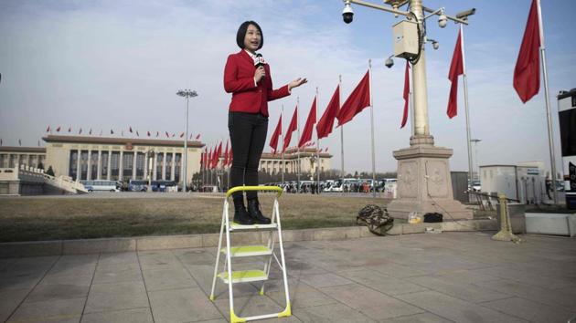A television journalist reports live ahead of the opening session of the National People's Congress, China's legislature, in Beijing's Great Hall of the People. (Nicolas Asfouri / AFP) A television journalist reports live ahead of the opening session of the National People's Congress, China's legislature, in Beijing's Great Hall of the People. (Nicolas Asfouri / AFP)